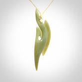 This photo shows a matau pendant carved from New Zealand Pounamu, Jade. The artist, Shaun Gardiner, has carved this beautifully. We provide this piece with an adjustable oat coloured cord. This is a fantastic work of art, we have one only.